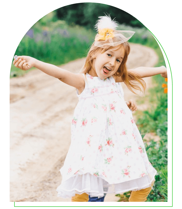 A little girl is standing on the side of a road.