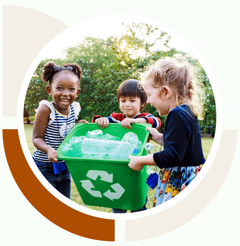 Three children are playing with a green recycling bin.