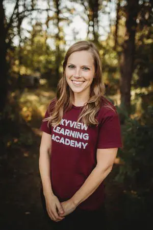 A woman standing in front of some trees