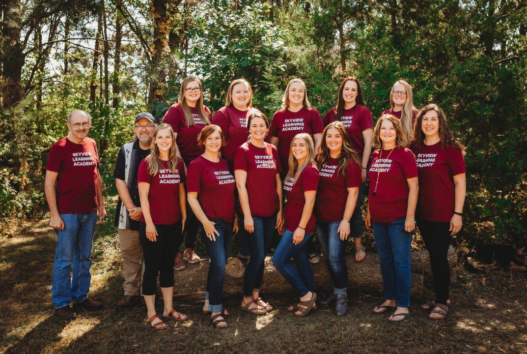 A group of people standing in front of trees.